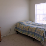 Bedroom with bed, dresser, and TV