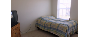 Bedroom with bed, dresser, and TV