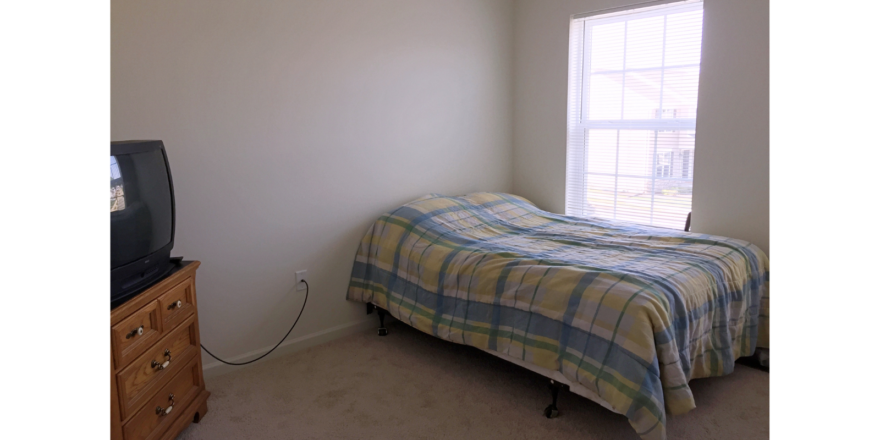 Bedroom with bed, dresser, and TV