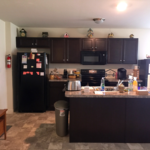 Kitchen with dark cabinets and black appliances