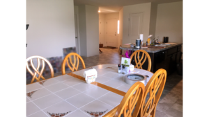 Kitchen with table, island and view of front door