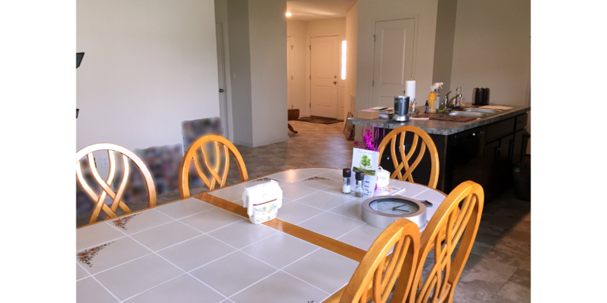 Kitchen with table, island and view of front door