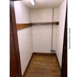 Closet with hardwood floors and clothes bar and shelf