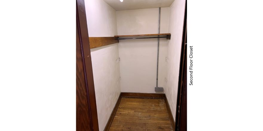 Closet with hardwood floors and clothes bar and shelf