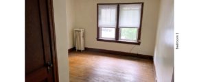 Unfurnished bedroom with hardwood floors, closet, and large windows