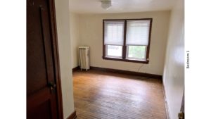 Unfurnished bedroom with hardwood floors, closet, and large windows