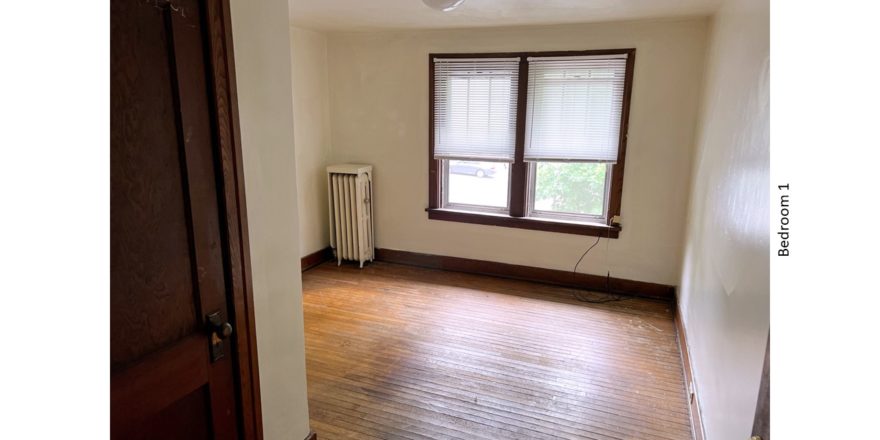 Unfurnished bedroom with hardwood floors, closet, and large windows