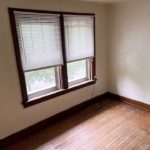 Unfurnished bedroom with hardwood floors and large windows