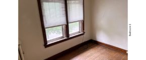 Unfurnished bedroom with hardwood floors and large windows