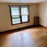 Unfurnished bedroom with hardwood floors and large windows