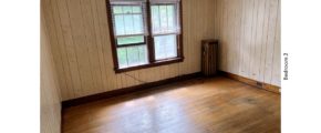 Unfurnished bedroom with hardwood floors and large windows