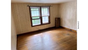Unfurnished bedroom with hardwood floors and large windows