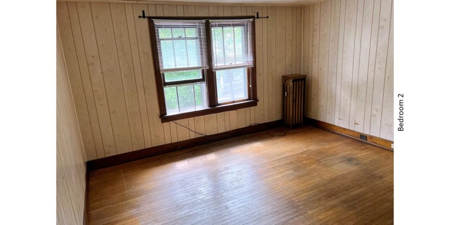Unfurnished bedroom with hardwood floors and large windows