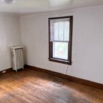 Unfurnished bedroom with hardwood floor and large window