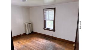 Unfurnished bedroom with hardwood floor and large window