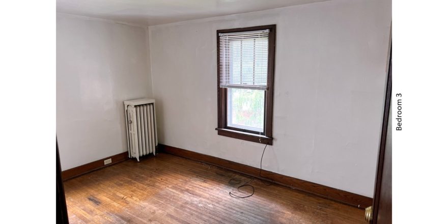 Unfurnished bedroom with hardwood floor and large window