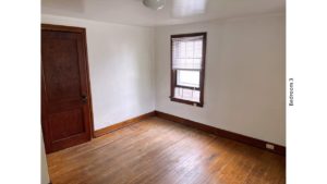 Unfurnished bedroom with hardwood floors, closet, and large window