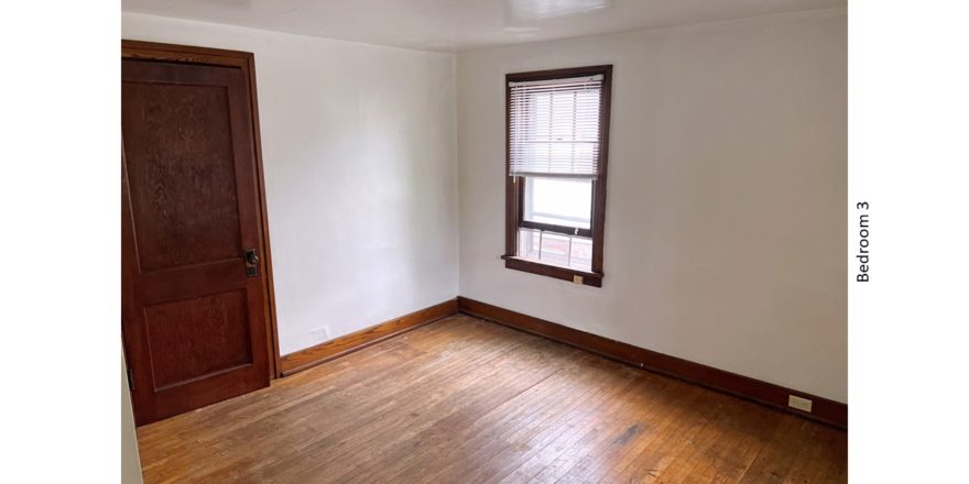 Unfurnished bedroom with hardwood floors, closet, and large window
