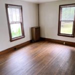 Unfurnished dining room with large windows and hardwood floors