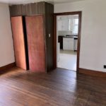 Unfurnished dining room with hardwood floors and large cupboard.