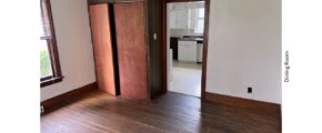 Unfurnished dining room with hardwood floors and large cupboard.