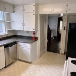 Kitchen with many cabinets, white range oven, black fridge, and stainless steel dishwasher
