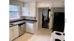 Kitchen with many cabinets, white range oven, black fridge, and stainless steel dishwasher