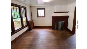 Unfurnished living room with large picture window and decorative fireplace