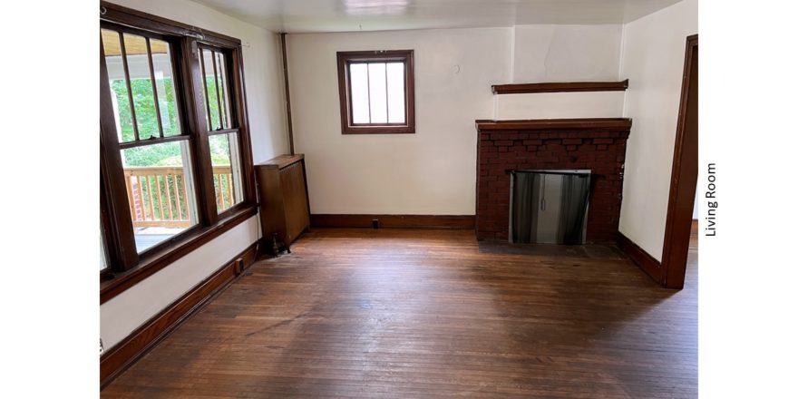 Unfurnished living room with large picture window and decorative fireplace