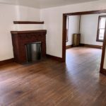Unfurnished living room with hardwood floors and decorative fireplace