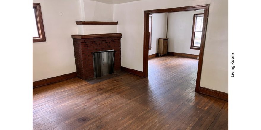 Unfurnished living room with hardwood floors and decorative fireplace