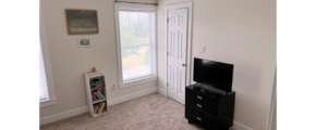 Bedroom with bookshelf, dresser, and TV