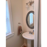 Half bathroom with pedestal sink and mirror