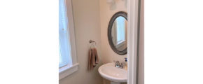 Half bathroom with pedestal sink and mirror