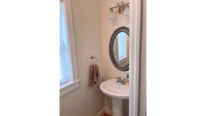 Half bathroom with pedestal sink and mirror