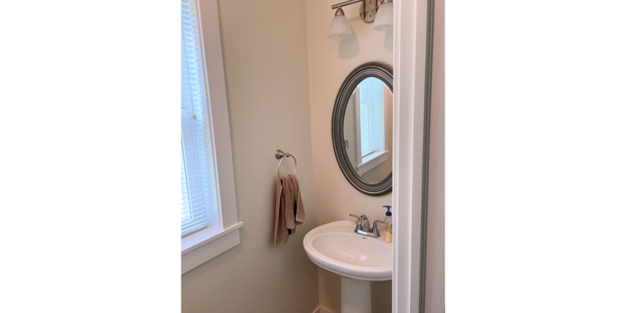 Half bathroom with pedestal sink and mirror