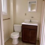 Bathroom with toilet, vanity, and mirror