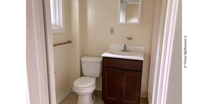 Bathroom with toilet, vanity, and mirror