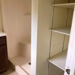 Bathroom with vanity, shower stall, and built-in shelving