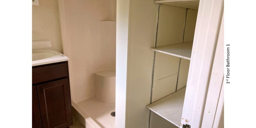 Bathroom with vanity, shower stall, and built-in shelving