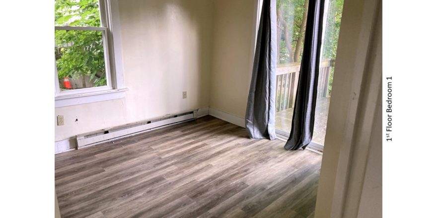 Bedroom with laminate flooring, and slider door to patio