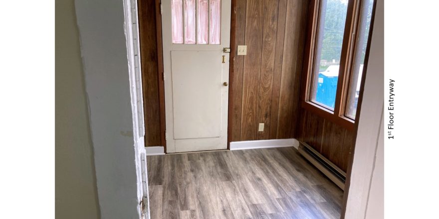 Entryway with large windows and wood paneling