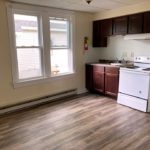 Great room with large windows, range oven, sink, and kitchen cabinets