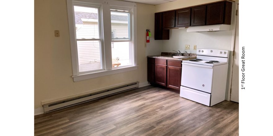 Great room with large windows, range oven, sink, and kitchen cabinets