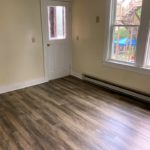 Great room with large windows and door to entryway