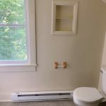 Bathroom with built-in shelving and toilet