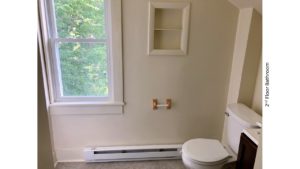 Bathroom with built-in shelving and toilet