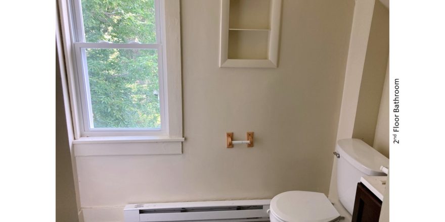 Bathroom with built-in shelving and toilet