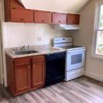 Kitchen with wood-tone cabinets, sink, black dishwasher, and white range oven