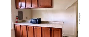 Kitchen counter with wood-tone cabinets and black microwave